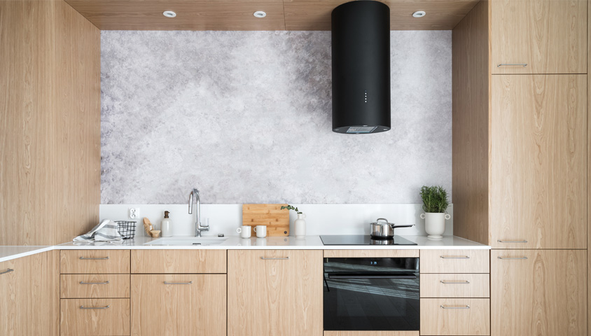 A modern kitchen featuring flat custom cabinets and a wood-look finish inside a luxury apartment.