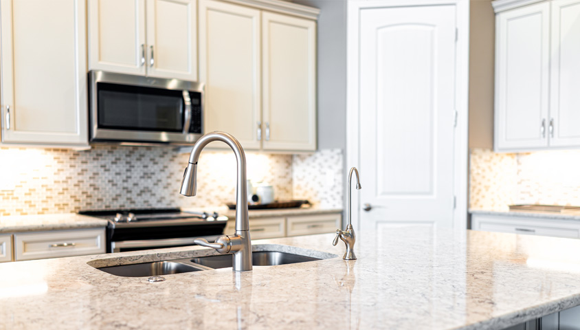 A luxurious custom granite kitchen countertop and white cabinets in a modern renovated kitchen.