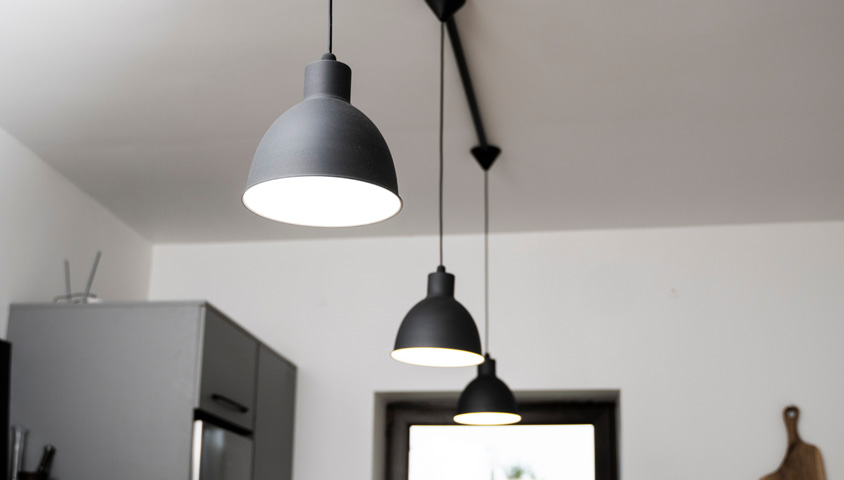 Black pendant lights hang overhead in this newly renovated modern kitchen