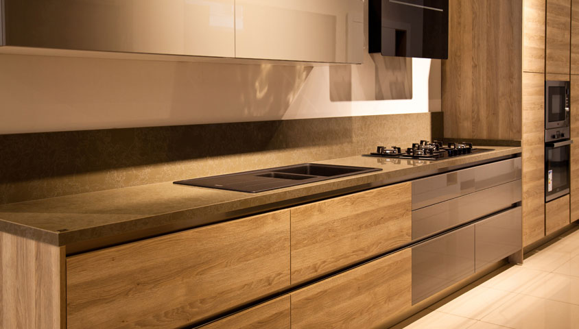 Newly renovated all-brown kitchen with wood cabinetry and a brown granite backsplash and benchtop 