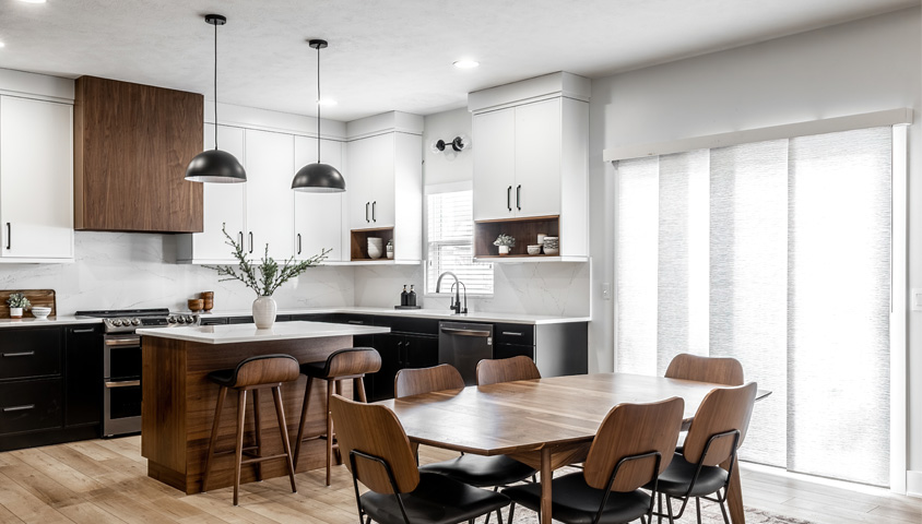 An open-concept kitchen island working as a divider between a dining room and kitchen in a renovated mid-century modern style